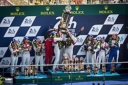 Marcel Fassler, Andre Lotterer, and Benoit Treluyer hoist the winners trophy during the podium ceremony 2014 Le Mans Podium.jpg