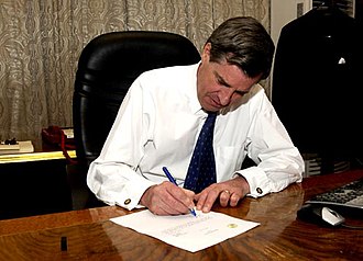 Coalition Provisional Authority director L. Paul Bremer signs over sovereignty to the appointed Iraqi Interim Government, 28 June 2004. Bremer signing.jpg