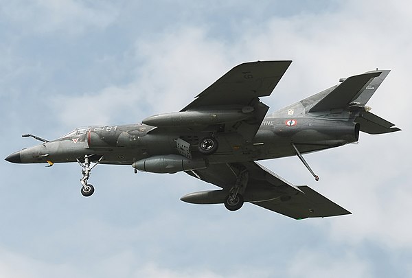 Underside of a Super Étendard in-flight. The protruding tail hook is towards the rear of the fuselage