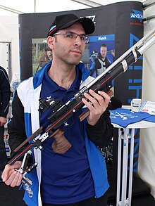 גיל סימקוביץ' מחזיק רובה לתצוגה