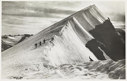 Characteristic snow drift on Glittertind (photo from 1910, most of the snow cap had receded by 2020 and left bare rock on the summit). Caution is needed on snow and around glaciers.