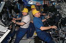 Cosmonauts Fyodor Yurchikhin (left) and Oleg Kotov, along with astronaut Clay Anderson (right) wearing yellow hard hats in a less serious moment. ISS15 Crew with yellow hats.jpg