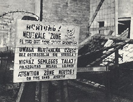 A multilingual sign saying that those who trespass the so-called "neutral zone" may be shot at without warning