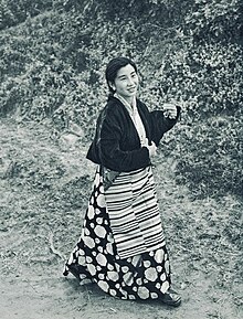 Kesang Choden. Schwarz-Weiß-Porträt einer jungen Frau mit dunklen Haaren und Perlen-Ohrring.