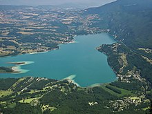 Panoramic view of Lake Aiguebelette. The village of Aiguebelette-le-Lac lies in the southeast corner of the picture.