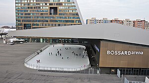 The Bossard Arena in the foreground, behind it is the uptown skyscraper.