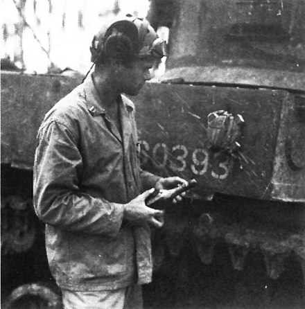 A Marine Captain inspects an un-exploded Type 99 mine attached to his M3A1 Stuart during the Battle of Munda Point in August, 1943