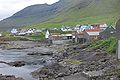 Ved stranden ses de typiske færøske bådehuse.