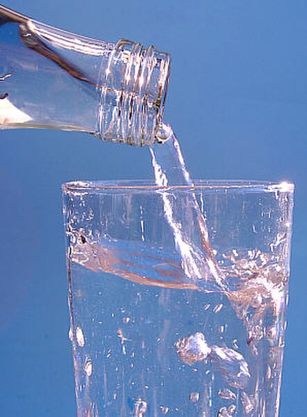 Bottled mineral water being poured into a glass