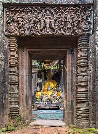 Stone gate with columns and Buddhist reliefs leading to a clothed statue of the Buddha seated, Wat Phou temple, Champasak, Laos