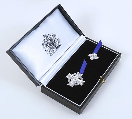 The medal, and a miniature version, are presented in a black leather-style presentation box with the Royal Cypher on the lid and the Royal Coat of Arms on the inner silk lining.