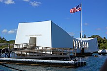 white rectangular memorial building with US flag flying above