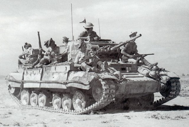Valentine tank in the desert, carrying an infantry section.