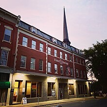 A building front is shown at dusk.