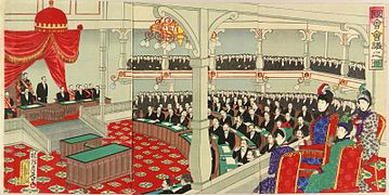Ukyo-e présentant la salle principale de l'assemblée japonaise. Au premier plan sont assises deux Japonaises vêtues de robes occidentales, surplombant dans un balcon les députés réunis en demi-cercle.