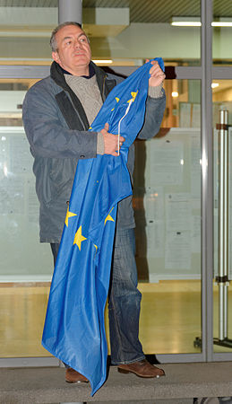 Yannick Hervé, avec le drapeau européen, expliquant pourquoi il l'a enlevé du fronton de la mairie d'Audincourt.