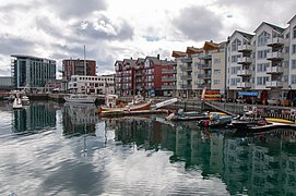 Foto von direkt an der Küste gelegenen mehrstöckigen Häusern, im Wasser mehrere Boote