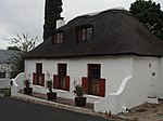 Free-standing extensively altered single storey cottage with attic; full hipped thatched roof; sash windows with leaded lights and solid shutters; double casement dormer windows; all joinery unpainted and appears to be modern stock; raised stoep with end Type of site: House Current use: House. 3 Victoria Street, Wynberg.JPG