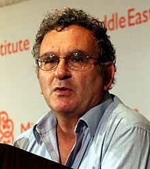 Benny Morris wearing light blue open-necked shirt, 