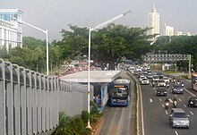 A TransJakarta bus on a dedicated bus lane, an exclusive right-of-way separated from heavy traffic. Bundaran Senayan Transjakarta stop.jpg