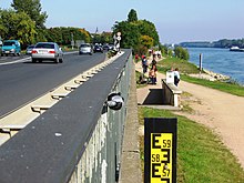 Rheinpegel an der Bundesstraße 42 bei Stromkilometer 513. Die Anzeige am Pegelstab reicht bis 6,00 Meter. Bei 5,46 Meter wird hier die Fahrbahn überspült, bei 6,08 Meter steht die Leitplanke unter Wasser. Im Jahr 1988 wurde hier ein Pegel von 5,80 Meter erreicht.