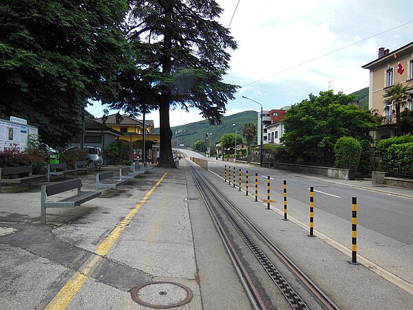 Looking south along Capolago's main street, with the railway station (in yellow) and the track of Monte Generoso railway