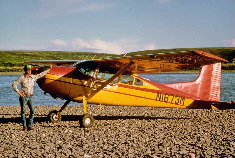 File:Cessna 185 - Man standing next to a small old airplane.jpg