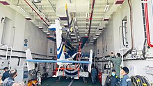 Dhruv Mk.III towed inside the hangar of an Indian Coast Guard patrol vessel.