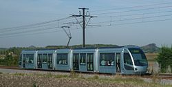 Une des rames du Tramway de Valenciennes. Le terril Audiffret Sud est visible à gauche de l'image, les terrils Haveluy Nord et Sud à droite.