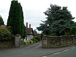 Lodge, among trees, at the entrance to a country house