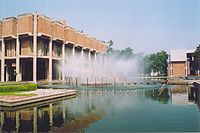 Låg modern byggnad, med stor pool och fontäner framför