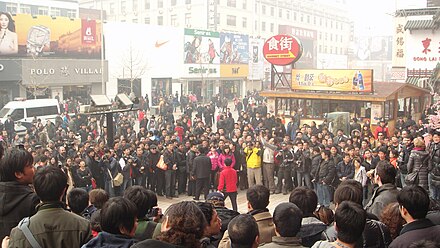 A large crowd of protesters, journalists, police and spectators gathered in front of a McDonald's restaurant in Wangfujing, Beijing during the 2011 Chinese pro-democracy protests.
