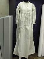 19th-century simple white cotton nightgown with embroidery insertion and lace trimming.