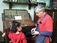 Peter Small showing a student how Ben Franklin set type by hand. PrintMus 026.jpg