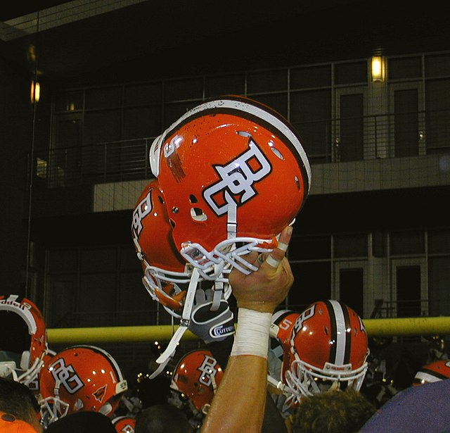 A Falcons football helmet held in the air by a football player in 2009