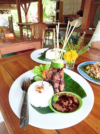 A fancy presentation of Balinese pork satay, the skewers are erected holds by cucumber, Ubud, Bali.