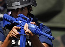 U.S. Navy sailor training with an M4 "blue gun". USS Harpers Ferry, Subic Bay, Philippines, 2009 Ship's Serviceman secures spaces during security reaction force (SRF) training scenario.jpg