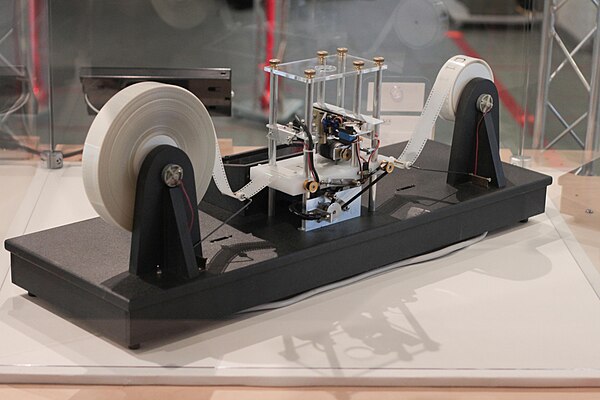 A physical Turing machine model. A true Turing machine would have unlimited tape on both sides; however, physical models can only have a finite amount
