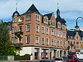 Apartment building with shops in a corner and open development