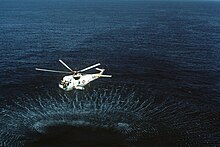 SH-3 Sea King dipping a sonar, 1983 Air-to-air left side view of a Navy SH-3D Sea King helicopter assigned to Helicopter Anti-Submarine Squadron 84 during flight operations. The AQS-13 dipping sonar is deployed by the - DPLA - 8666d7f9762dede2ba027b46944fda62.jpeg