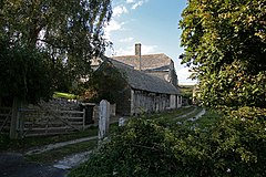 Gate with stone building in background and trees in the foreground