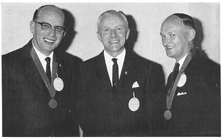From L-R: S. Willam (Bill) Hayes, G. Ronald Davies (Director of Evans Medical Australia), P. Lance Jeffs Bill Hayes and Lance Jeffs receive their Evans Medal for Merit from Ronald Davies.jpg