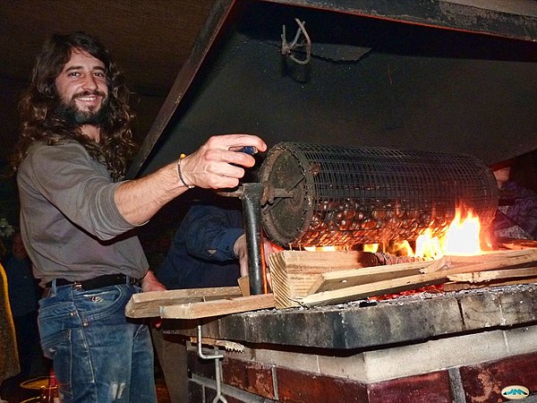 Man roasting chestnuts on an open fire.