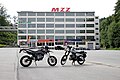 Ein Gebäude des ehemaligen Motorradwerks, heute Gewerbepark. Vorn eine MZ 125 SM, Bj. 2008 und eine MZ ETZ 150, Bj. 1989