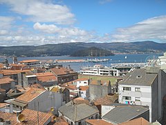 Elcano atracando na escola naval Militar e vista parcial da vila.