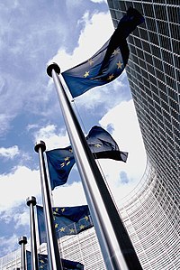 The building of the European Commission where the EU FTT proposal was drafted European flag outside the Commission.jpg