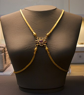 Front view of the gold body chain from the Hoxne Hoard. Visible are an amethyst and four garnets; four other gems are missing, thought to have been pearls.[44]
