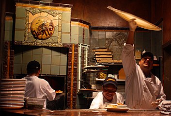 Traditional pizza dough being tossed