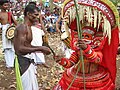 അമ്പും വില്ലുമേന്തിയ കാലിച്ചാൻ തെയ്യവും വെളിച്ചപ്പാടനും