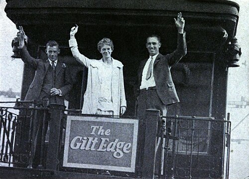 Earhart and company wave from the rear platform of a train labeled "The Gilt Edge"